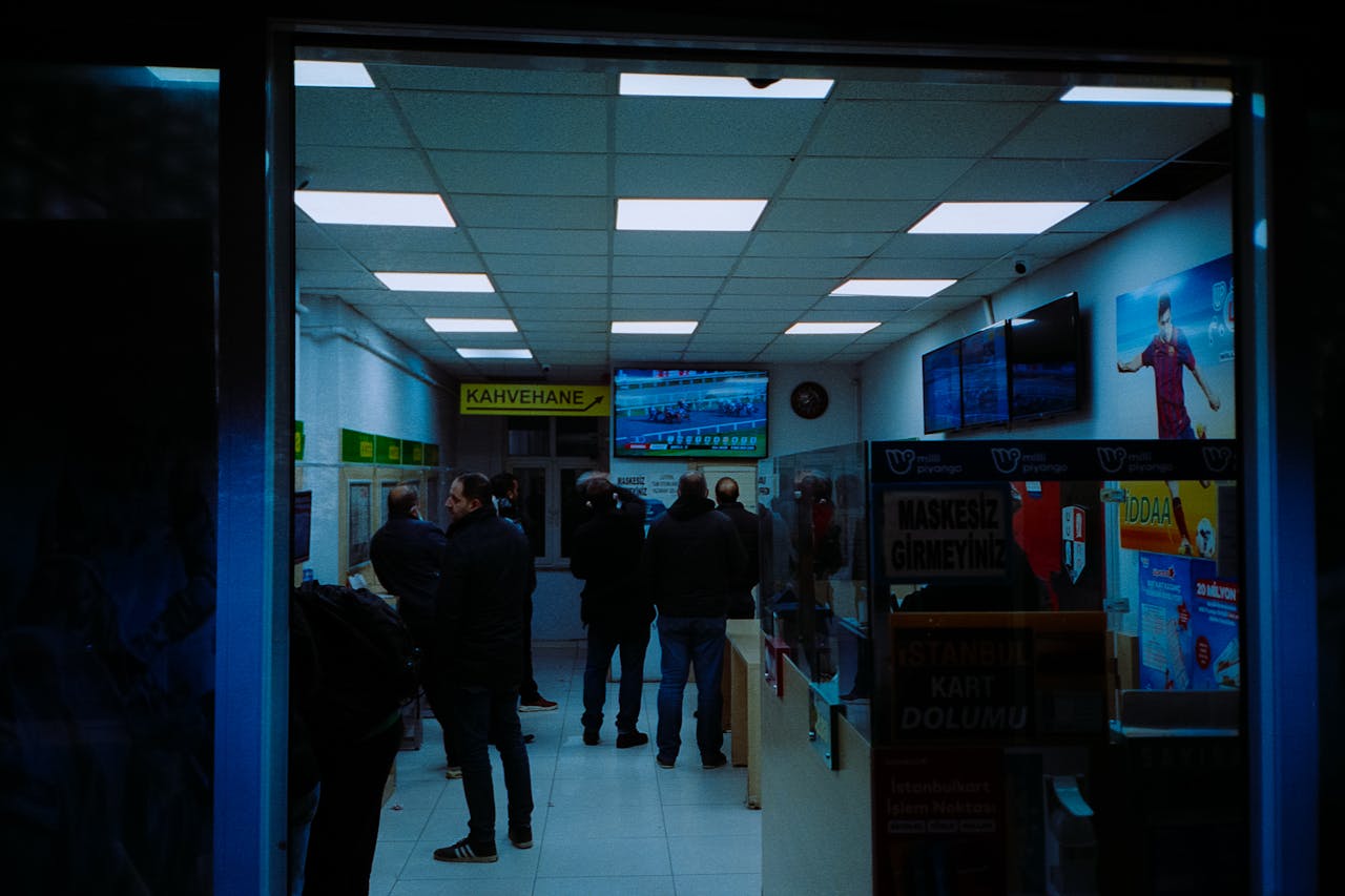 Interior of a Turkish betting cafe with people watching sports and placing bets.